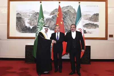 En esta foto publicada por la Agencia de Noticias Xinhua, Ali Shamkhani, secretario del Consejo Supremo de Seguridad Nacional de Irán, a la derecha, estrecha la mano del asesor de seguridad nacional saudí Musaad bin Mohammed al-Aiban, a la izquierda, mientras Wang Yi, el diplomático de más alto rango de China, observa, en el centro, una foto durante una reunión cerrada celebrada en Beijing, el sábado 11 de marzo.  2023. Irán y Arabia Saudita acordaron el viernes restablecer las relaciones diplomáticas y reabrir embajadas después de siete años de tensiones. El importante avance diplomático negociado con China reduce la posibilidad de un conflicto armado entre los rivales de Medio Oriente, tanto directamente como en conflictos de poder en toda la región. (Luo Xiaoguang/Xinhua vía AP)