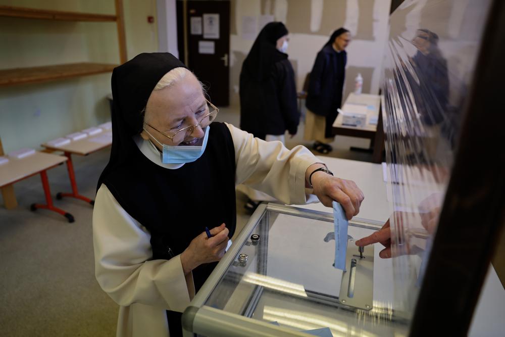 Una monja de la abadía de Baumgarten emite su voto en la primera ronda de las elecciones presidenciales francesas, en Bernardville, este de Francia, el domingo 10 de abril de 2022. Las urnas se abrieron a las 8 a. m. en Francia para la primera ronda de las elecciones presidenciales donde hasta 48 millones de votantes franceses elegibles elegirán entre 12 candidatos.  (Foto AP/Jean-Francois Badias)