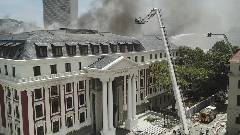 This photo supplied by the City of Cape Town shows smoke rising from the Houses of Parliament, in Cape Town, South Africa, Sunday, Jan. 2, 2022. Firefighters are still working at the Parliament complex Monday after a major blaze tore through the precinct Sunday. (Bruce Sutherland/City of Cape Town via AP)