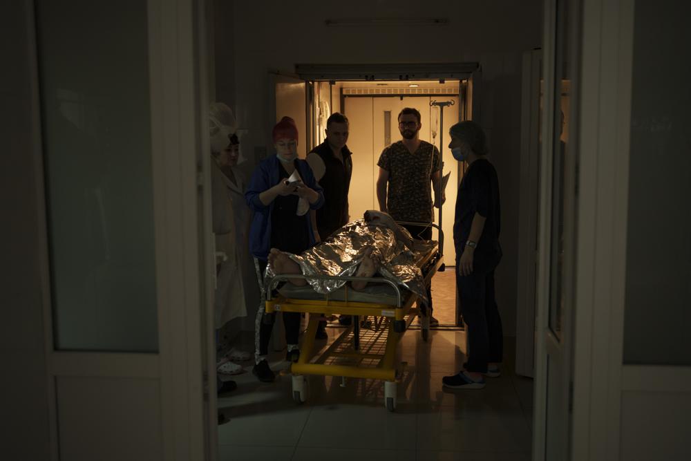 Medical staff transfer an injured Ukrainian soldier to the operating room as the Russian attack continues in Kharkiv, Ukraine, Friday, March 25, 2022. (AP Photo/Felipe Dana)
