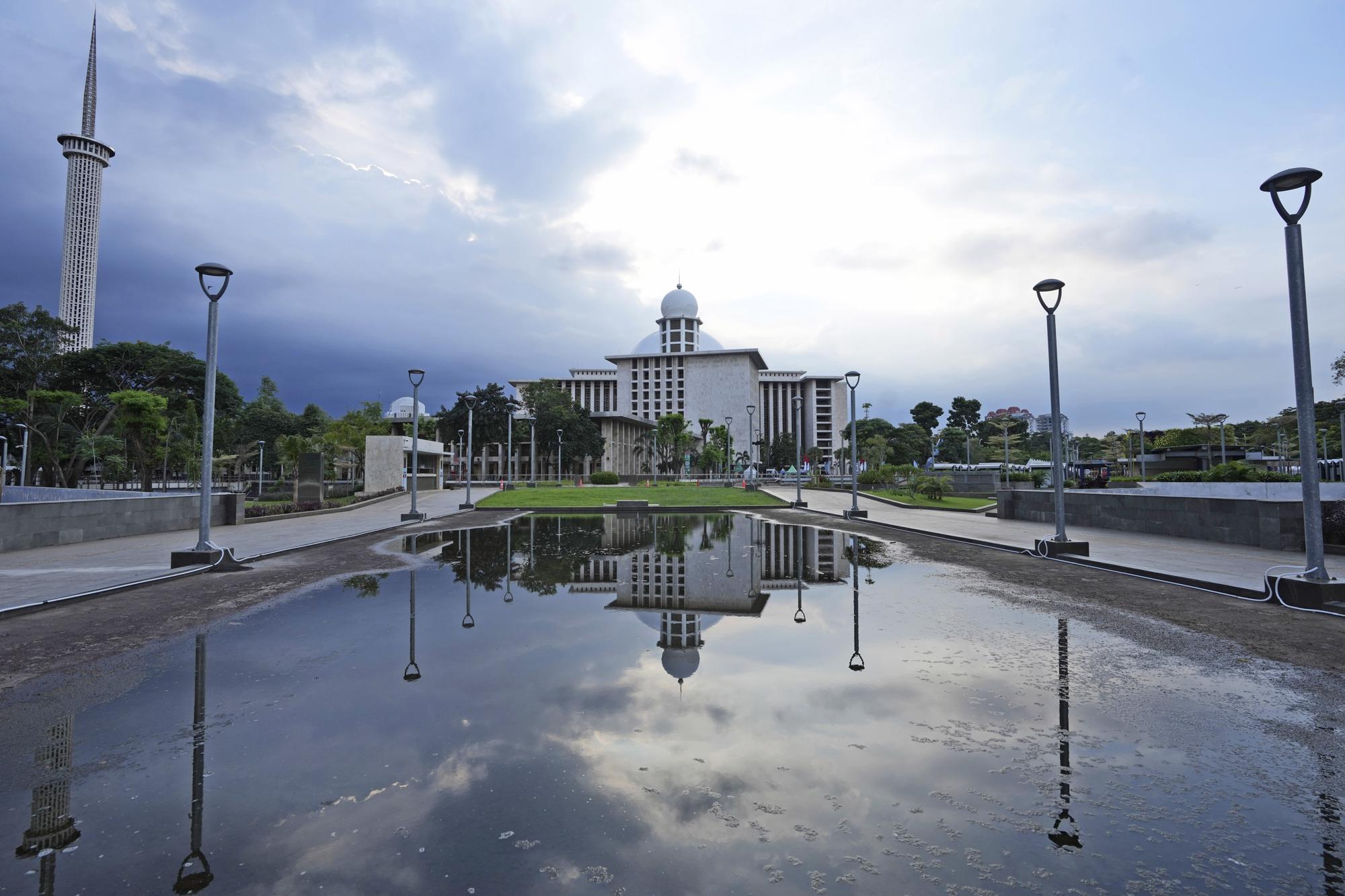 Istiqlal Mosque is reflected in a puddle of water in Jakarta, Indonesia, Wednesday, March 29, 2023. "Green Ramadan" initiatives in Indonesia and around the world promote an array of changes during the Muslim holy month, which has fasting and, in many cases, feasting elements as people gather around food to break their fasts. (AP Photo/Tatan Syuflana)