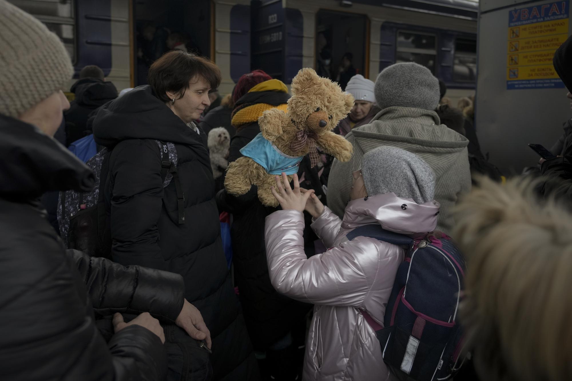 A child plays with a teddy bear while waiting to board a Lviv bound train, in Kyiv, Ukraine, Thursday, March 3, 2022. (AP Photo/Vadim Ghirda)