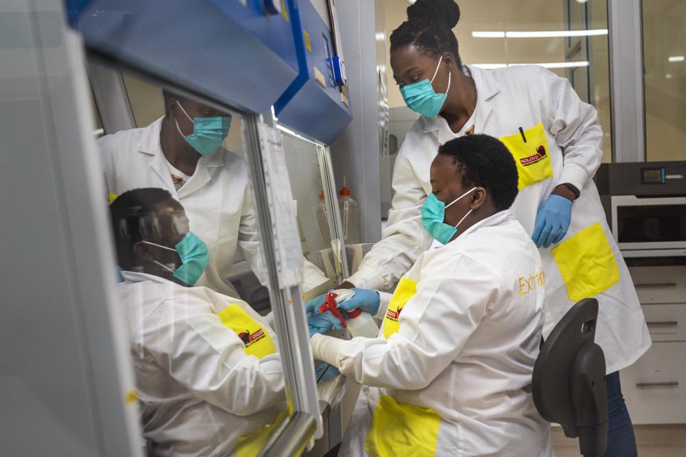 FILE — Melva Mlambo, right, and Puseletso Lesofi, both medical scientists prepare to sequence COVID-19 omicron samples at the Ndlovu Research Center in Elandsdoorn, South Africa, Dec. 8, 2021. Health experts still don't know if omicron is causing milder COVID-19 but some more hints are emerging with doctors in South Africa saying their patients aren't getting as sick with omicron, compared to the delta variant. (AP Photo/Jerome Delay, File)