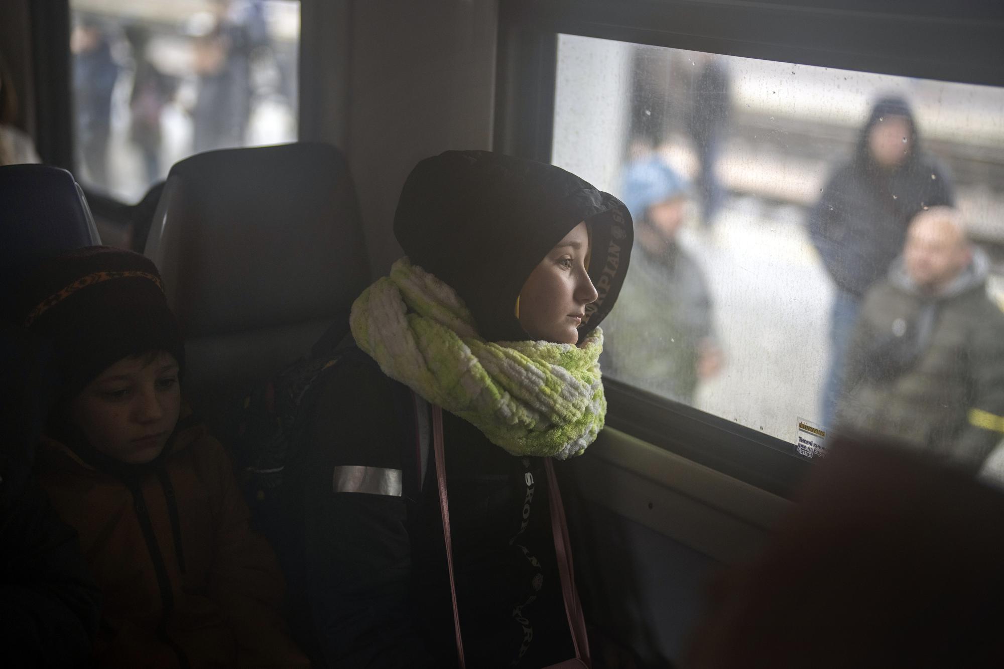 A girl and her brother sit on a train bound for Lviv at the Kyiv station, Ukraine, Thursday, March 3, 2022. (AP Photo/Emilio Morenatti)