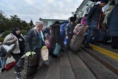 Residentes evacuados de Jersón avanzan luego de llegar a la estación de tren en Dzhankoi, Crimea, el viernes 21 de octubre de 2022. Las autoridades rusas han alentado a los residentes a evacuar la urbe, advirtiendo que la ciudad puede sufrir un bombardeo de Ucrania. (AP Foto)