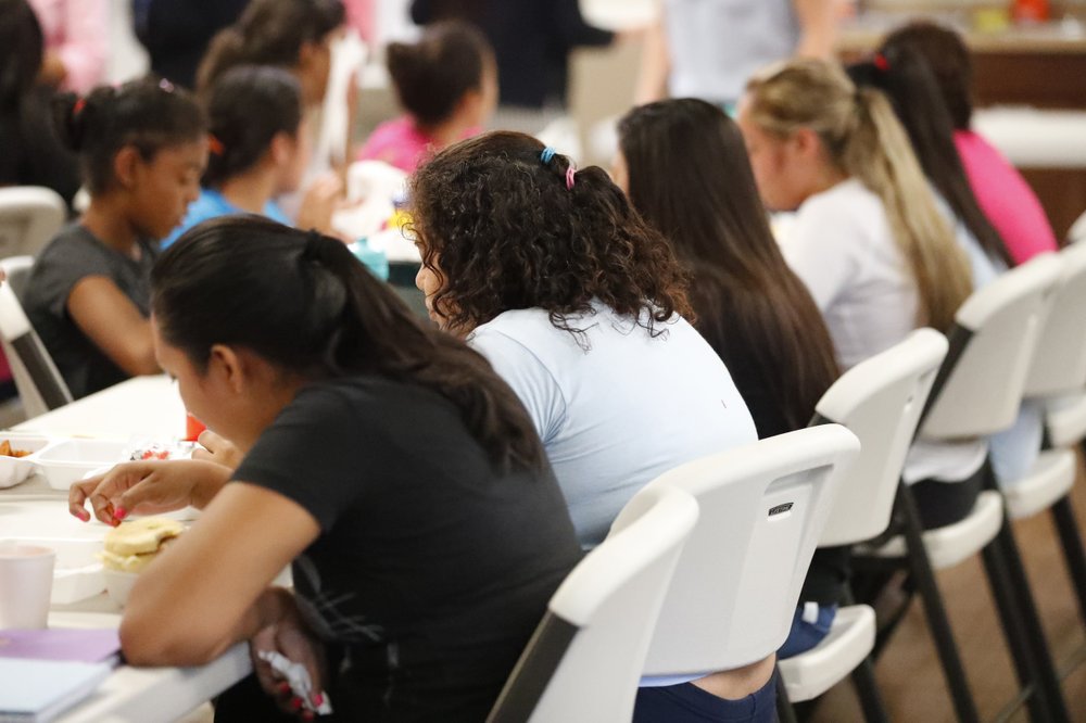 In this Sept. 24, 2019 photo, girls eat lunch at a shelter for migrant teenage girls, in Lake Worth, Fla. The nonprofit U.S. Committee for Refugees and Immigrants opened the federally funded Rinconcito del Sol shelter, aiming to make it a model of excellence in a system of 170 detention centers, residential shelters and foster programs which held nearly 70,000 migrant kids in the past year. (AP Photo/Wilfredo Lee)