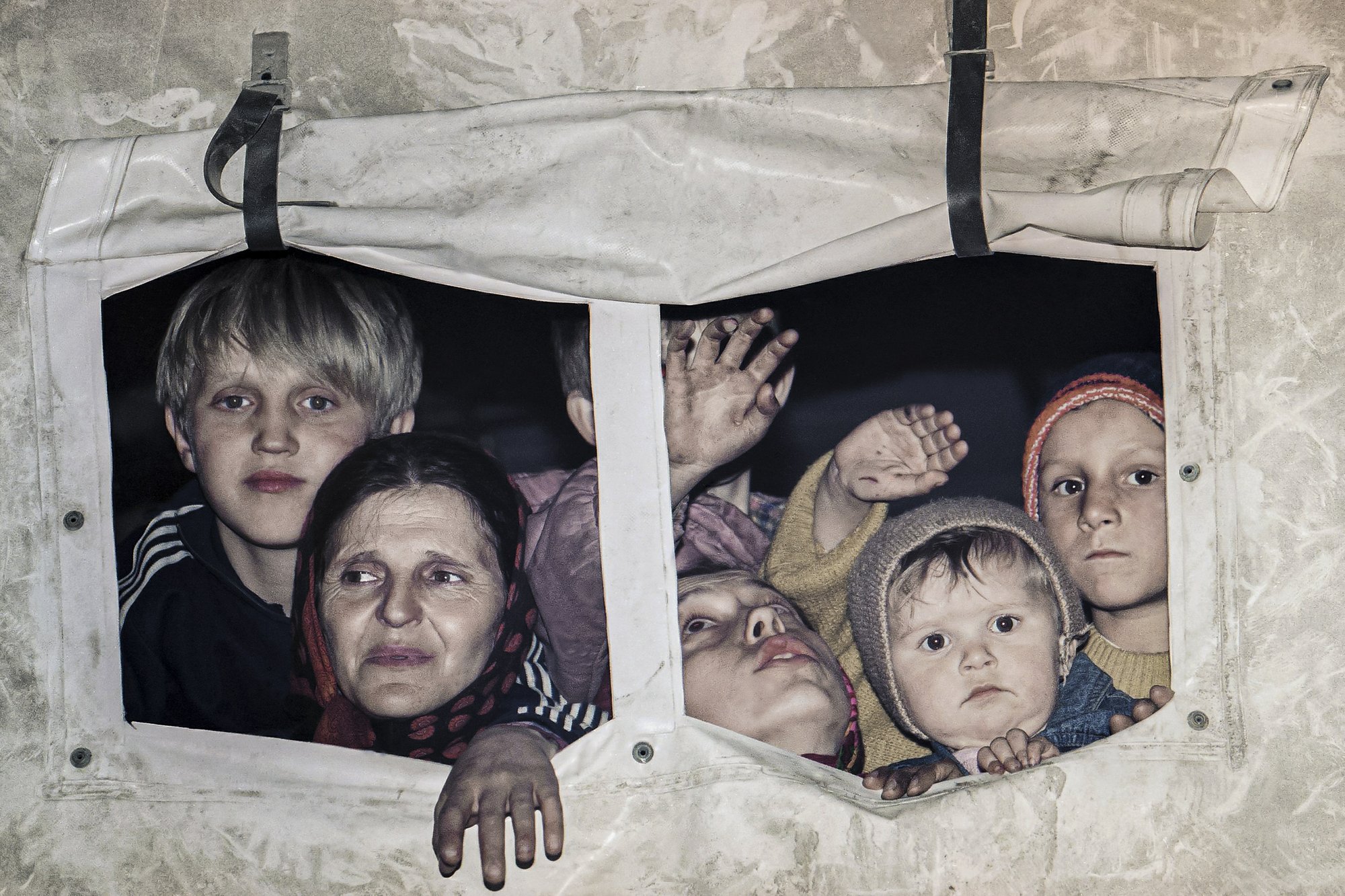 FILE- In this March 20, 1993, file picture evacuees form Srebrenica look out from a U.N. truck in Medgas, Bosnia, north of Sarajevo, as a U.N. truck convoy carrying people from the besieged Bosnian town made its way to Tuzla.  Survivors of the genocide in the eastern Bosnian town of Srebrenica, mainly women, will on Saturday July 11, 2020, commemorate the 25th anniversary of the slaughter of their fathers and brothers, husbands and sons.  At least 8,000 mostly Muslim men and boys were chased through woods in and around Srebrenica by Serb troops in what is considered the worst carnage of civilians in Europe since World War II. The slaughter was also the only atrocity of the brutal war that has been confirmed an act of genocide.(AP Photo/Michel Euler, File)