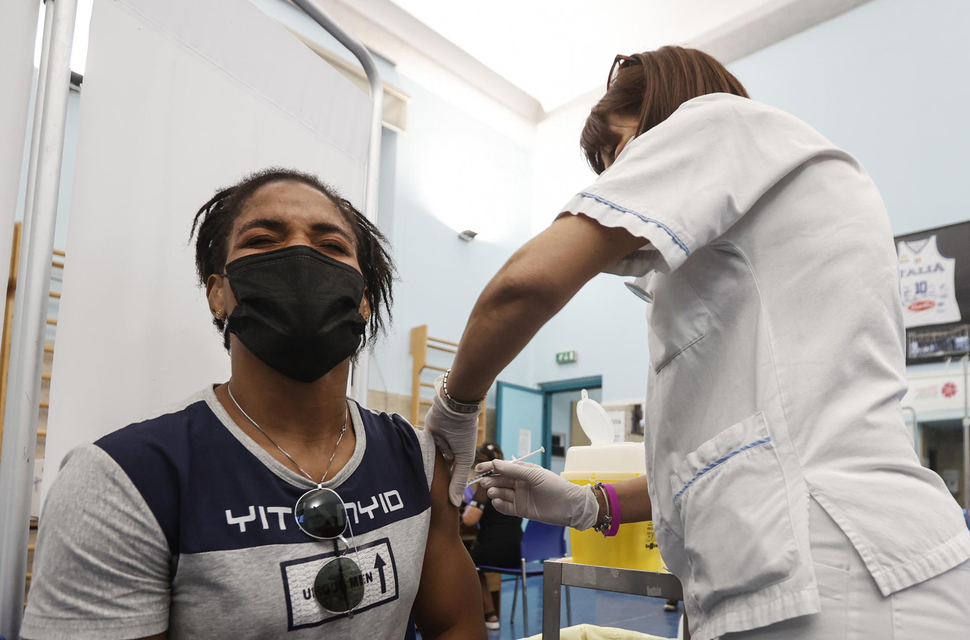 Freestyle wrestler Fatoumata Yarie Camara, of Guinea, receives the COVID-19 vaccine at the Santo Spirito hospital in Rome, Saturday, July 3, 2021. A West African wrestler's dream of competing in the Olympics has come down to a plane ticket. Fatoumata Yarie Camara is the only Guinean athlete to qualify for these Games. She was ready for Tokyo, but confusion over travel reigned for weeks. The 25-year-old and her family can't afford it. Guinean officials promised a ticket, but at the last minute announced a withdrawal from the Olympics over COVID-19 concerns. Under international pressure, Guinea reversed its decision.  (AP Photo/Riccardo De Luca)