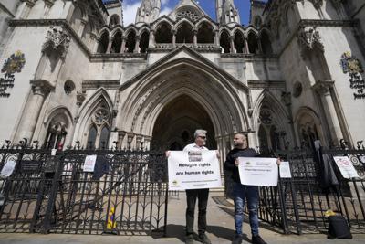 Manifestantes protestan frente a los Reales Tribunales de Justicia, el viernes 10 de junio de 2022, en Londres. (AP Foto/Frank Augstein)