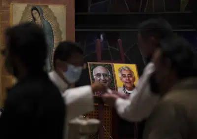ARCHIVO - Devotos toman la comunión en una misa fúnebre por la muerte de los sacerdotes jesuitas Javier Campos y Joaquín Mora, en una iglesia en Ciudad de México, el 21 de junio de 2022. La hermana de un líder de una organización criminal acusado de haber asesinado a los dos jesuitas en 2021 identificó un cuerpo encontrado en el norte de México como el de su hermano, según anunció la Fiscalía el miércoles 22 de marzo de 2023. (AP Foto/Fernando Llano, Archivo)