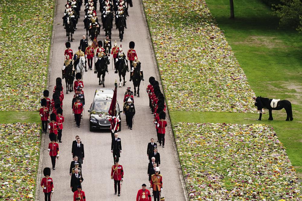 Emma, the monarch's fell pony, right, stands as the Ceremonial Procession of the coffin of Queen Elizabeth II arrives at Windsor Castle for the Committal Service at St George's Chapel, in Windsor, England, Monday, Sept. 19, 2022. (Aaron Chown/Pool photo via AP)