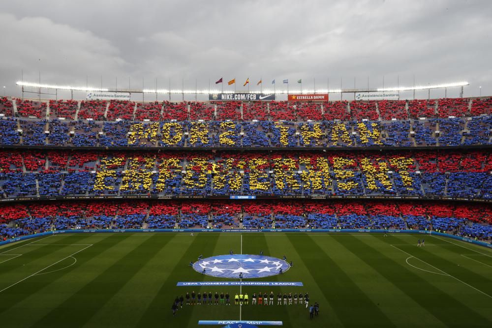 Partidarios sostienen pancartas que dicen "Más que empoderamiento" antes de los cuartos de final de la Liga de Campeones Femenina, partido de vuelta entre Barcelona y Real Madrid en el estadio Camp Nou de Barcelona, ​​España, el miércoles 30 de marzo de 2022. (Foto AP/Joan Monfort)