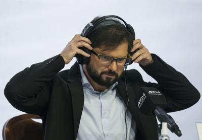 Gabriel Boric del partido de coalición Apruebo Dignidad se pone los auriculares antes de iniciar un debate presidencial organizado por la Asociación de Radio de Chile, en Santiago, Chile, el viernes 10 de diciembre de 2021. Chile vota en segunda vuelta el 19 de diciembre. (AP Foto/Esteban Felix)