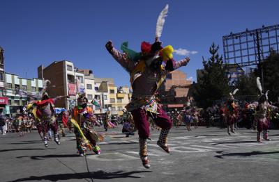 Los bailarines, con máscaras protectoras en medio de la pandemia de coronavirus, interpretan Tinku durante un desfile que marca la festividad de la Virgen del Carmen o Nuestra Señora del Monte Carmelo, en El Alto, Bolivia, el viernes 16 de julio de 2021. (Foto AP/Juan Karita)