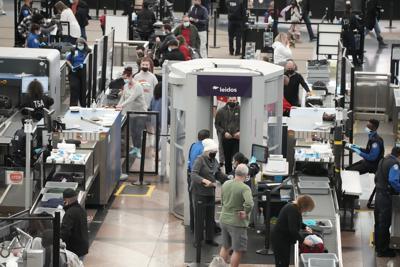 Viajeros pasan por el punto sur de revisión de seguridad de la terminal del Aeropuerto Internacional de Denver, el domingo 26 de diciembre de 2021, en Denver. (AP Foto/David Zalubowski)