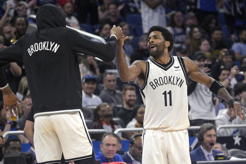 Brooklyn Nets guard Kyrie Irving (11) celebrates with forward Kevin Durant, left, after Irving scored his 60th point of the game in the second half of an NBA basketball game against the Orlando Magic, Tuesday, March 15, 2022, in  Orlando, Fla. (AP Photo/Phelan M. Ebenhack)