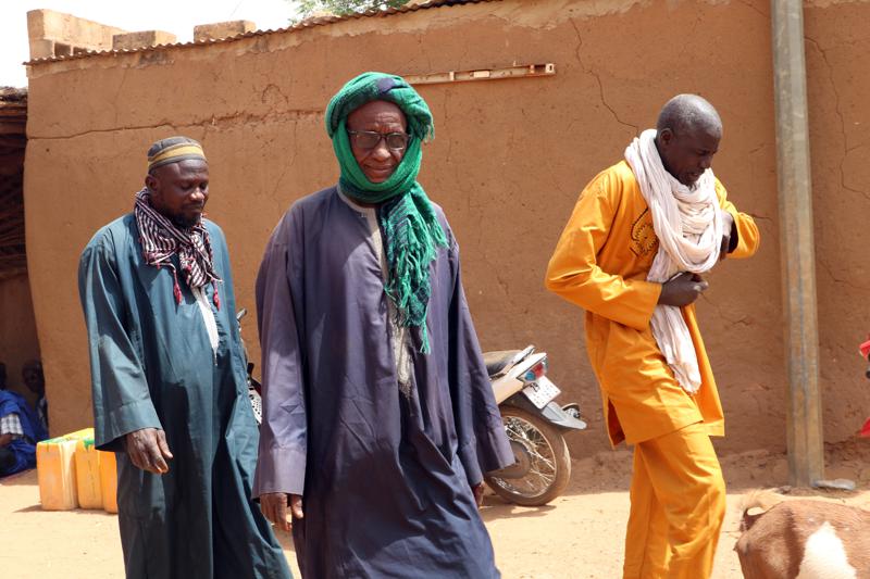 Men who were jailed for years on suspicion of being affiliated with Jihadist organisations but later released without charges, walk in Djibo town, Burkina Faso, Feb. 18, 2021. While Burkina Faso's government never confirmed negotiating with Islamic extremists, others said the lull in fighting earlier this year was a sign that a cease-fire of sorts had been reached with the militants blamed for thousands of deaths in recent years. (AP Photo/Sam Mednick)