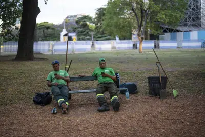Limpiadores de calles toman un descanso en una plaza de la Ciudad de Buenos Aires, Argentina, el 7 de diciembre de 2022. La Comisión Económica para América Latina y el Caribe (CEPAL) estima que la región crecerá un 3,7% en 2022, casi la mitad del 6,7% registrado en 2021; y sólo un 1,3% el año próximo (AP Foto/Rodrigo Abd)