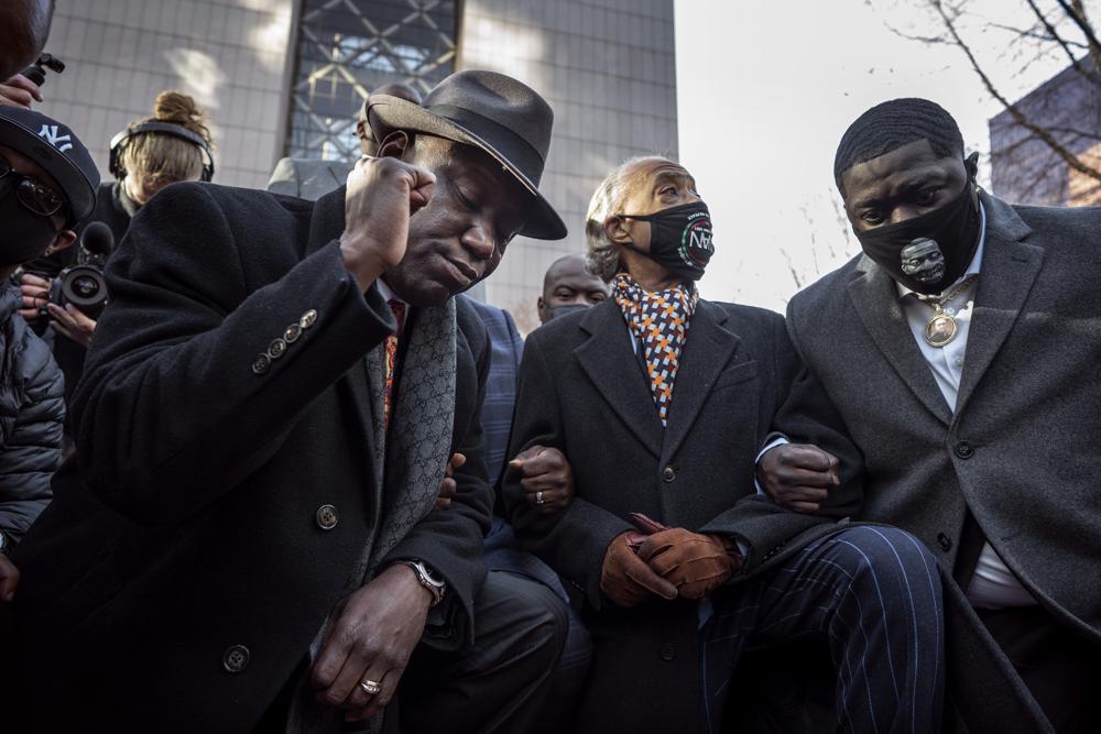 FILE - From left, attorney Ben Crump, the Rev. Al Sharpton and Brandon Williams, nephew of George Floyd, take a knee for 8 minutes and 46 seconds in Minneapolis, Minn., in this March 29, 2021 file photo. The Benjamin L. Crump Center for Social Justice, housed at the St. Thomas University College of Law in Miami Gardens, Fla., will announce on Thursday, Dec. 2, the creation of a social justice center named after Ben Crump, the Black civil rights attorney who has gained national notoriety representing victims of police brutality and vigilante violence. (Jerry Holt/Star Tribune via AP, File)