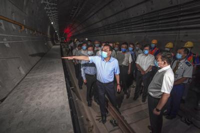 El primer ministro chino Li Keqiang (izq, con máscara) visita la zona de inundaciones en la ciudad de Zhengzhou, provincia de Henan, China, el 18 de agosto de 2021. Foto cortesía de la agencia de noticias Xinhua. (Rao Aimin/Xinhua via AP)