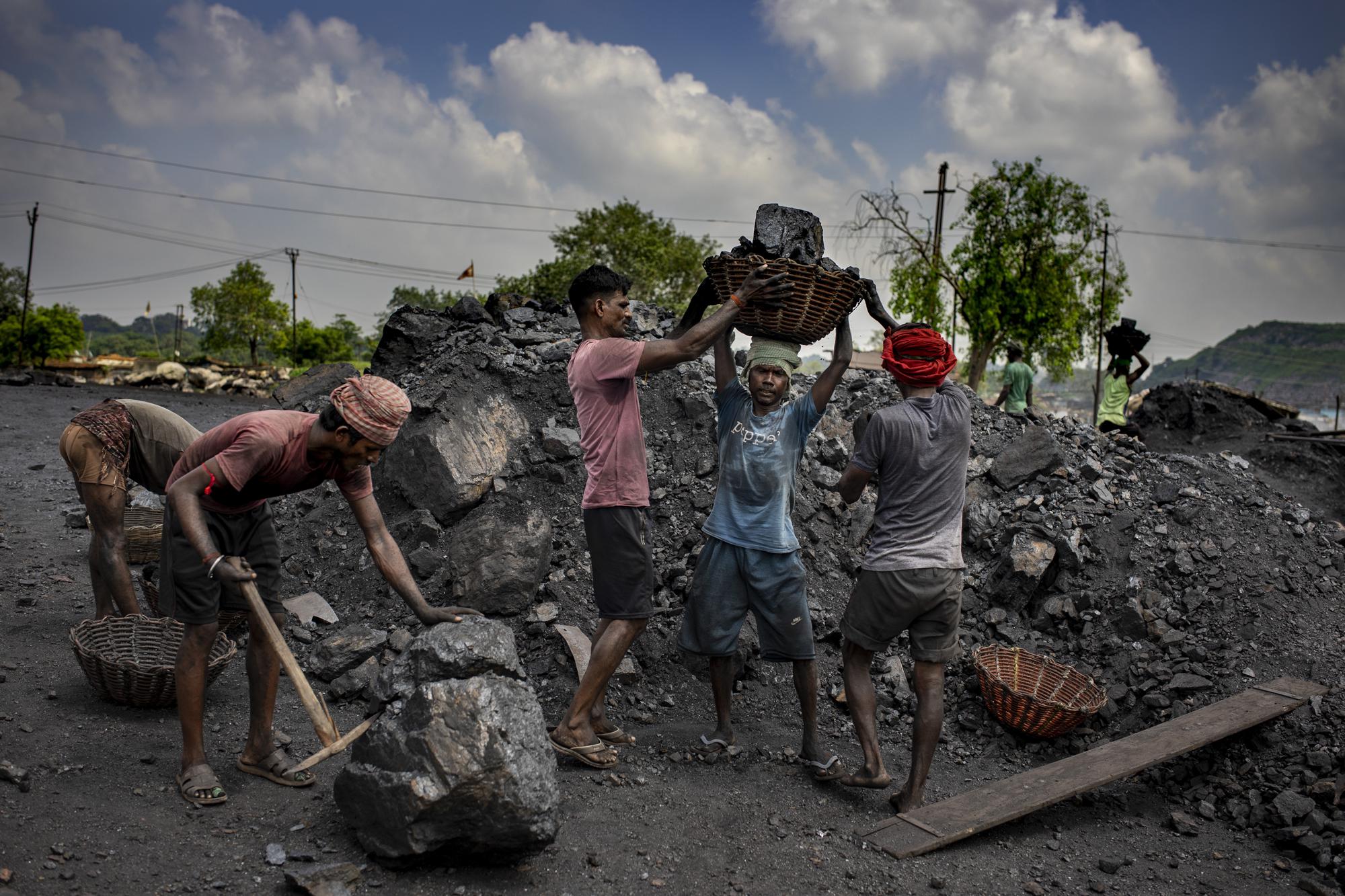 Laborers load coal onto trucks for transportation near Dhanbad, an eastern Indian city in Jharkhand state, Friday, Sept. 24, 2021. A 2021 Indian government study found that Jharkhand state -- among the poorest in India and the state with the nation’s largest coal reserves -- is also the most vulnerable Indian state to climate change. Efforts to fight climate change are being held back in part because coal, the biggest single source of climate-changing gases, provides cheap electricity and supports millions of jobs. It's one of the dilemmas facing world leaders gathered in Glasgow, Scotland this week in an attempt to stave off the worst effects of climate change. (AP Photo/Altaf Qadri)