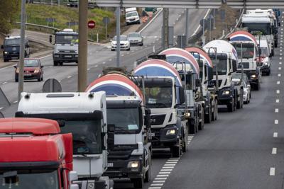 Camiones circulan en fila durante una protesta por el elevado precio de los combustibles, a las afueras de Madrid, España, el 24 de marzo de 2022. (AP Foto/Manu Fernandez)