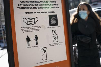 ARCHIVO - Una mujer con mascarilla para protegerse del COVID-19 camina por Broadway en el distrito de SoHo, el viernes 4 de marzo de 2022, en Nueva York. (AP Foto/John Minchillo, archivo)