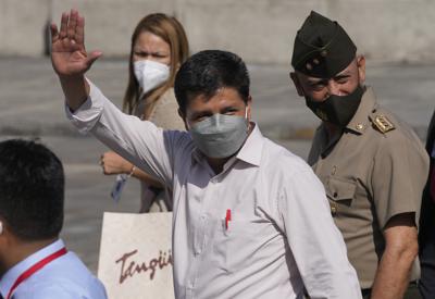 El presidente de Perú, Pedro Castillo, saluda a los periodistas después de que su gabinete partió hacia el Congreso para pedir a los legisladores un voto de confianza en Lima, Perú, el martes 8 de marzo de 2022. Castillo juró el cuarto gabinete de su medio año en el cargo el martes en medio de críticas por su malas elecciones previas para los ministros e incluso llamados de sus rivales a renunciar. (AP Foto/Martin Mejia)