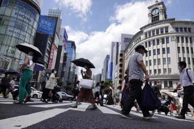 En esta imagen de archivo, tomada el 10 de agosto de 2021, varias personas, con mascarilla para ayudar a frenar la propagación del coronavirus, caminan bajo un sol abrasador por el distrito comercial de Ginza, en Tokio. (AP Foto/Eugene Hoshiko, archivo)