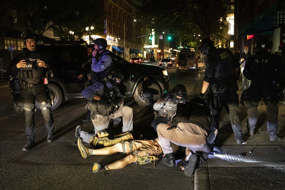A man is being treated after being shot Saturday, Aug. 29, 2020, in Portland, Ore. Fights broke out in downtown Portland Saturday night as a large caravan of supporters of President Donald Trump drove through the city, clashing with counter-protesters. (AP Photo/Paula Bronstein)