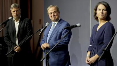 Desde la izquierda, Robert Habeck, copresidente del partido alemán de los Verdes (Die Gruenen), Armin Laschet, presidente del Partido Democristiano Alemán (CDU), y Annalena Baerbock, copresidenta de los Verdes, ofrecen una declaración tras una reunión en Berlín, Alemania, el martes 5 deoctubre de 2021. (AP Foto/Michael Sohn)