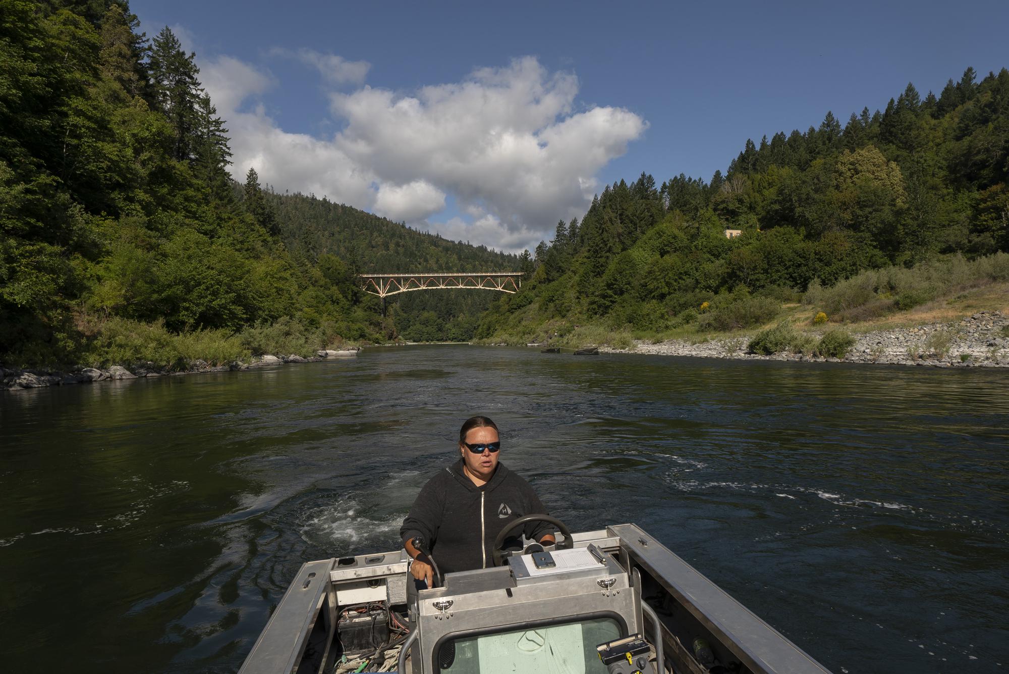 Jamie Holt, lead fisheries technician for the Yurok Tribe, maneuvers a boat near a fish trap in the lower Klamath River on Tuesday, June 8, 2021, in Weitchpec, Calif. A historic drought and low water levels are threatening the existence of fish species along the 257-mile long river. 