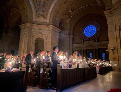 Cientos de personas con velas encendidas participan en la Misa de la Vigilia Pascual el sábado 16 de abril de 2022, en la Catedral de St. Paul, Minnesota. (AP Foto/Giovanna Dell'Orto)