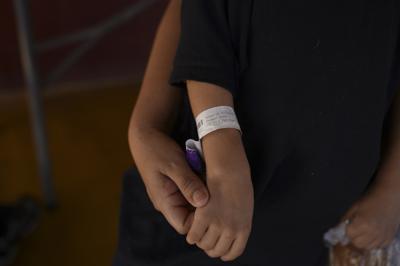 Zoe, de 5 años, sostiene la mano de su madre el jueves 12 de agosto de 2021 en el albergue "Casa del Migrante", en El Ceibo, Guatemala. (AP Foto/Santiago Billy)