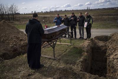 Familiares y amigos asisten al entierro de Andriy Matviychuk, de 37 años, que sirvió como soldado de defensa territorial y fue capturado y asesinado por el ejército ruso en Bucha, a las afueras de Kiev, Ucrania, el 12 de abril de 2022. (AP Foto/Rodrigo Abd)