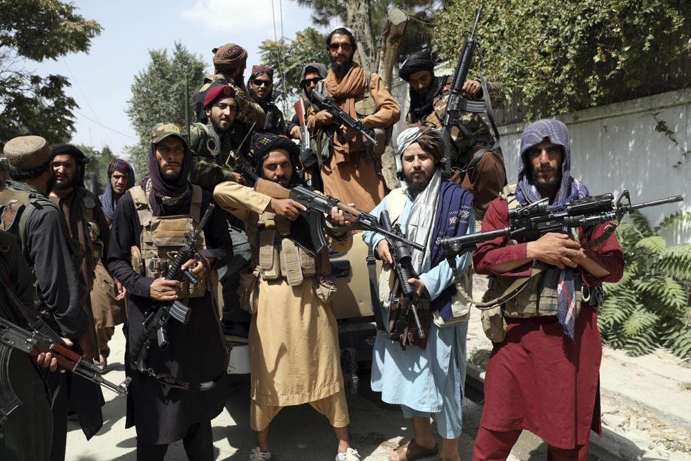 Taliban fighters pose for a photograph in Kabul, Afghanistan, Thursday, Aug. 19, 2021. The Taliban celebrated Afghanistan's Independence Day on Thursday by declaring they beat the United States, but challenges to their rule ranging from running a country severely short on cash and bureaucrats to potentially facing an armed opposition began to emerge. (AP Photo/Rahmat Gul)