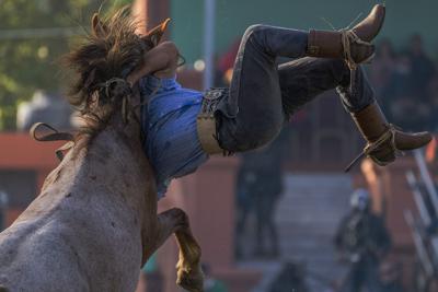 Un gaucho se aferra a las crines de un caballo mientras es zarandeado por el animal durante el rodeo de la "Semana criolla", una tradición de Semana Santa en Montevideo, Uruguay, el 14 de abril de 2022. Los "gauchos", el nombre con el que se conoce a los vaqueros de las llanuras de Uruguay y de las vecinas Argentina y Brasil, compiten por ver quien es capaz de mantenerse a lomos de un caballo salvaje de 8 a 10 segundos. (AP Foto/Matilde Campodonico)