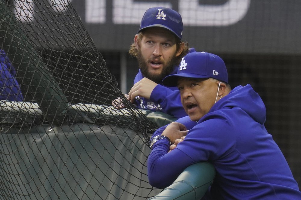 El manager de los Dodgers de Los Ángeles, Dave Roberts, y el lanzador abridor Clayton Kershaw miran la práctica de bateo antes del Juego 2 de la Serie Mundial de la MLB contra los Rays de Tampa Bay, el miércoles 21 de octubre de 2020.