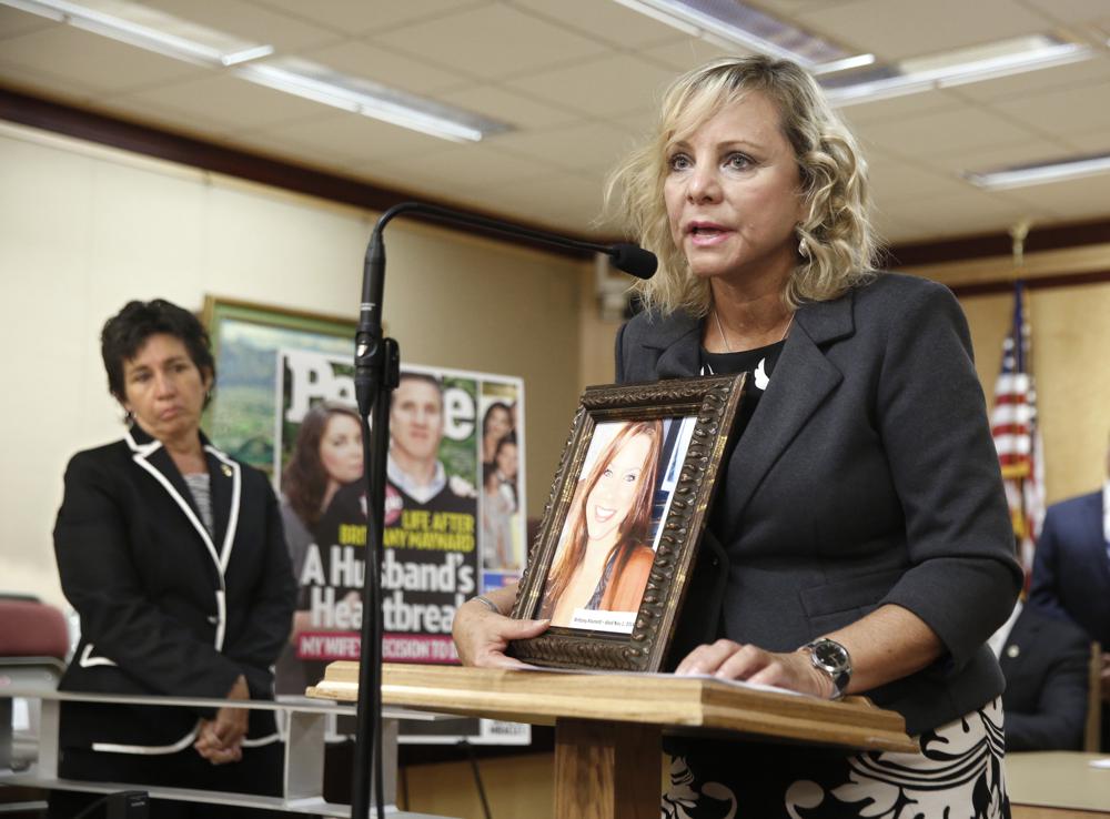 FILE — Debbie Ziegler holds a photo of her daughter, Brittany Maynard, the California woman with brain cancer who moved to Oregon to legally end her life, during a news conference to announce the reintroduction of right to die legislation, Tuesday, Aug. 18, 2015, in Sacramento, Calif. An appeals court formally ended a lawsuit, Monday, Nov. 1, 2021, that in 2018 temporarily suspended a law by then-Assemblywoman Susan Talamantes Eggman, D-Stockton, left, that allows adults to obtain prescriptions for life-ending drugs. (AP Photo/Rich Pedroncelli, File)