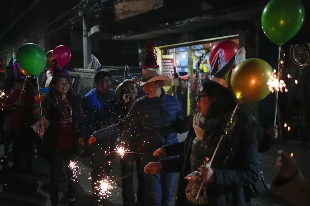 Residentes con bengalas participan en la procesión de "Niñopa" durante una posada navideña, en la delegación Xochimilco de la Ciudad de México, el miércoles 21 de diciembre de 2022. Durante los últimos 400 años, los residentes han realizado posadas entre los días 16 y 24 de diciembre, cuando llevan las estatuas del niño Jesús en procesión en conmemoración del frío y difícil viaje de María y José desde Nazaret a Belén en busca de refugio. (AP Foto/Eduardo Verdugo)