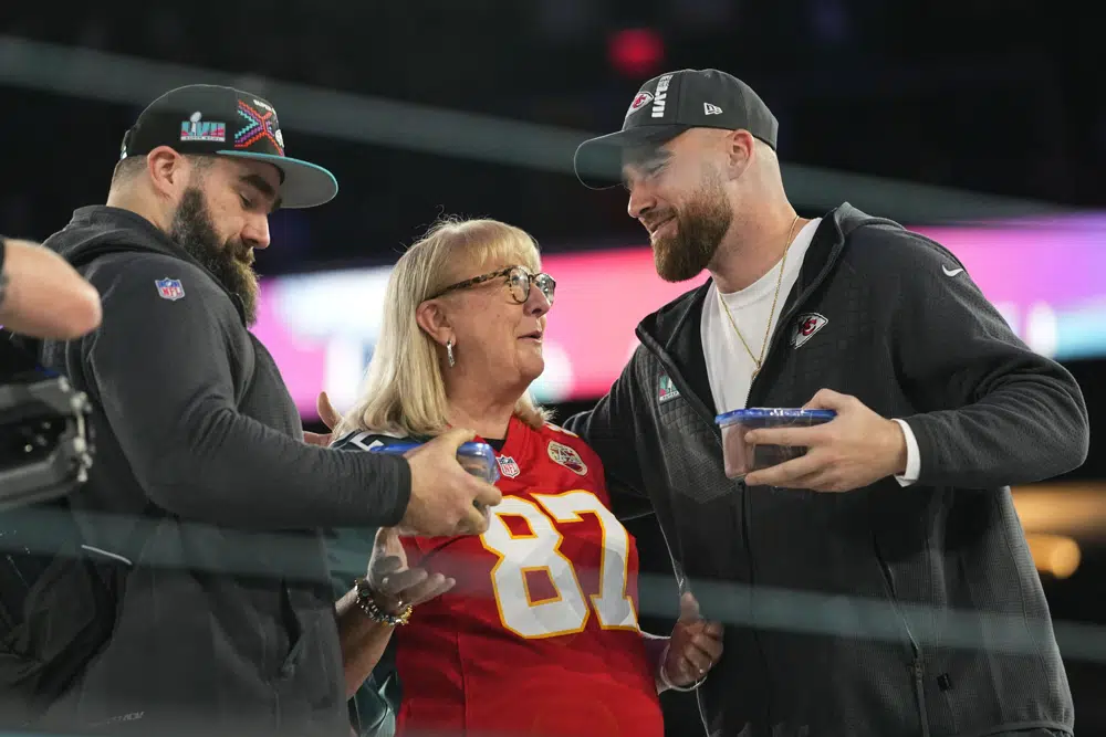Donna Kelce greets her sons, Philadelphia Eagles center Jason Kelce, left, and Kansas City Chiefs tight end Travis Kelce during the NFL football Super Bowl 57 opening night, Monday, Feb. 6, 2023, in Phoenix. The Kansas City Chiefs will play the Philadelphia Eagles on Sunday. (AP Photo/Matt York)