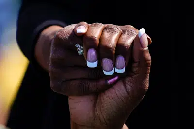 People hold hands as they pray outside the scene of a shooting at a supermarket in Buffalo, N.Y., Sunday, May 15, 2022. (AP Photo/Matt Rourke)