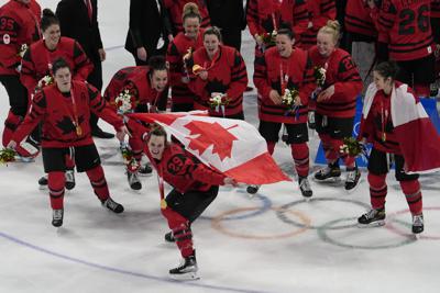 Canada's Marie-Philip Poulin (29) poses with her team after defeating the United States in the women's gold medal hockey game at the 2022 Winter Olympics, Thursday, Feb. 17, 2022, in Beijing. (AP Photo/Jae C. Hong)