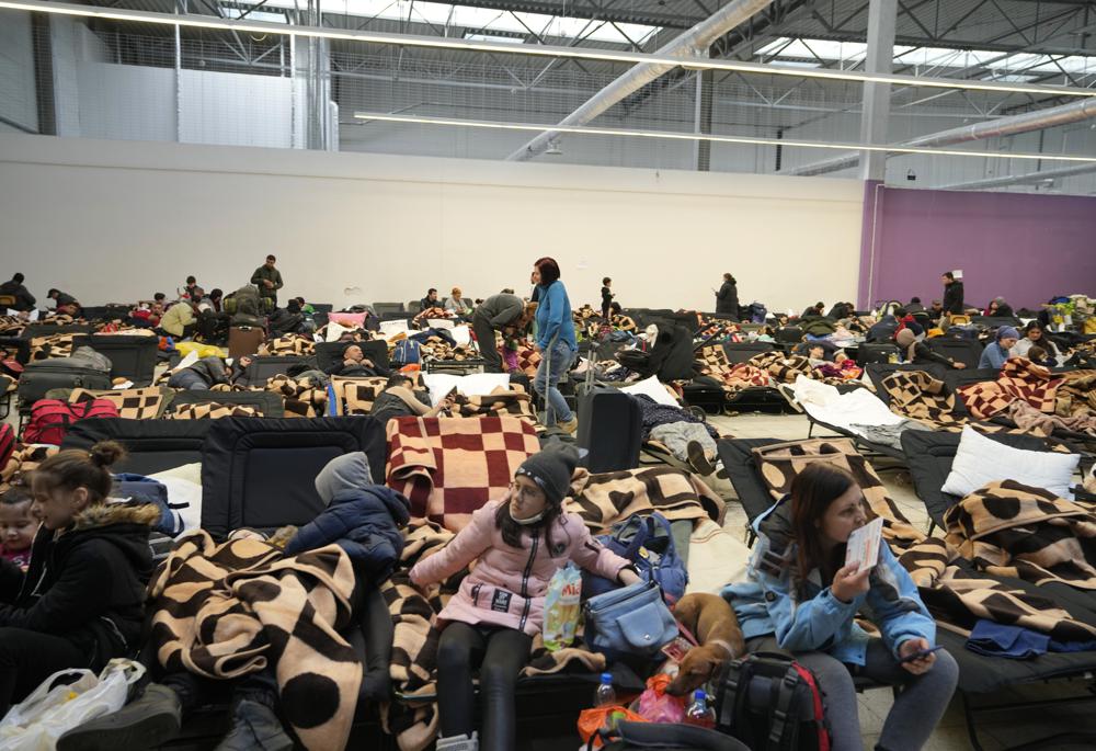Displaced people rest at a makeshift shelter in Mlyny, near the Korczowa border crossing, in Poland, Thursday, March 3, 2022. More than 1 million people have fled Ukraine following Russia's invasion in the swiftest refugee exodus in this century, the United Nations said Thursday. (AP Photo/Markus Schreiber)