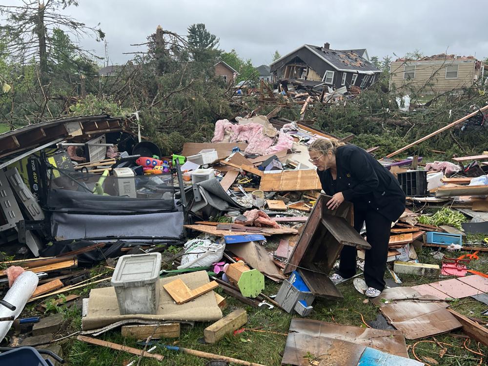 Theresa Haske clasifica los escombros que quedaron en su garaje después de que un tornado arrasara el viernes 20 de mayo de 2022 la comunidad de Gaylord, en el estado de Michigan.  (John Russell/Detroit News vía AP)