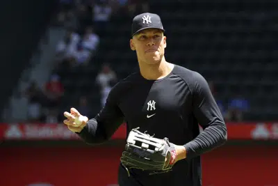 El jardinero central de los Yankees de Nueva York, Aaron Judge, realiza un par de lanzamientos de calentamiento antes de un juego de béisbol contra los Rangers de Texas el domingo 30 de abril de 2023 en Arlington, Texas. (AP Photo/Richard W. Rodríguez)