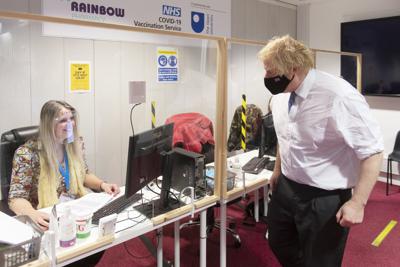 El primer ministro británico Boris Johnson visita un centro de vacunación contra COVID-19 en la Farmacia Rainbow en la Universidad Abierta del Reino Unido, en Milton Keynes, Inglaterra, el miércoles 29 de diciembre de 2021. (Geoff Pugh / Pool Photo vía AP)