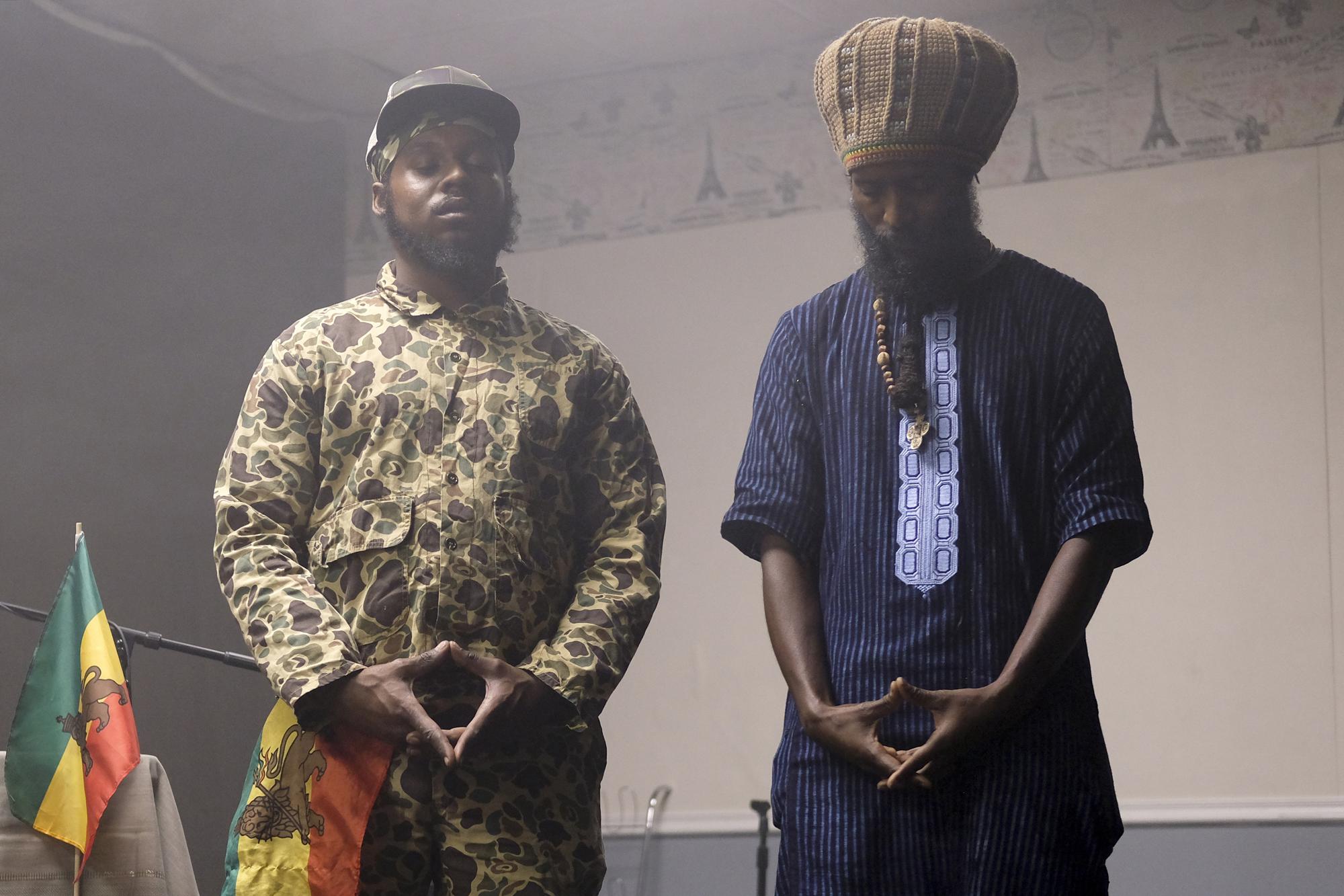 Ras Todd, izquierda, y el chef italiano Ras Mo cierran los ojos en oración durante un momento ritual en un evento organizado por la Coalición Rastafari con sede en Columbus, Ohio, que marca el 91 aniversario de la coronación del difunto emperador etíope Haile Selassie I el martes. 2 de noviembre de 2021 en Columbus, Ohio.  El evento del día de la coronación también incluyó cánticos, tambores tradicionales nyabinghi y lectura de salmos.  (Foto AP / Luis Andres Henao)