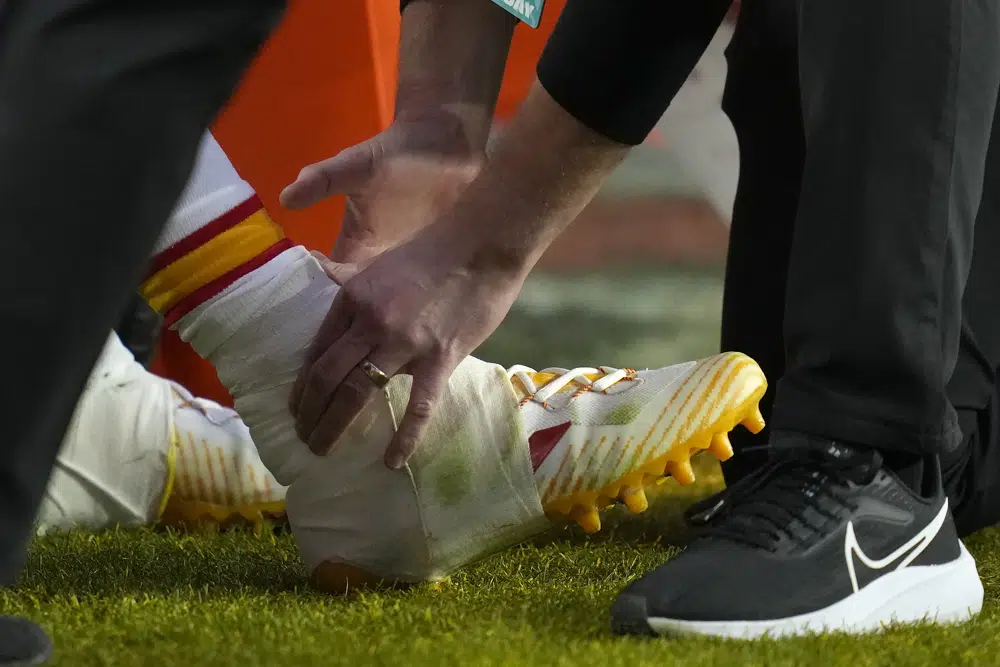 Kansas City Chiefs quarterback Patrick Mahomes's ankle is looked over by staff during the first half of the NFL Super Bowl 57 football game against the Philadelphia Eagles, Sunday, Feb. 12, 2023, in Glendale, Ariz. (AP Photo/Ashley Landis)