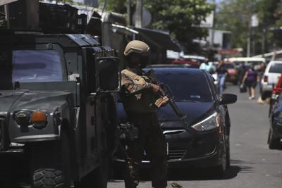 Soldados vigilan un puesto de control a la entrada de la comunidad de Las Palmas, un barrio que se supone está bajo el control de la pandilla Barrio 18 en San Salvador, El Salvador, el domingo 27 de marzo de 2022. (AP Foto/Salvador Meléndez)